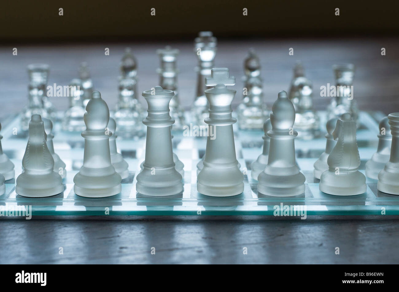 Eye level view of glass chess set on a wooden floor Stock Photo