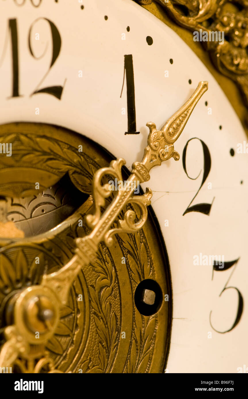 Close up of hand on clock face between one and two Stock Photo Alamy