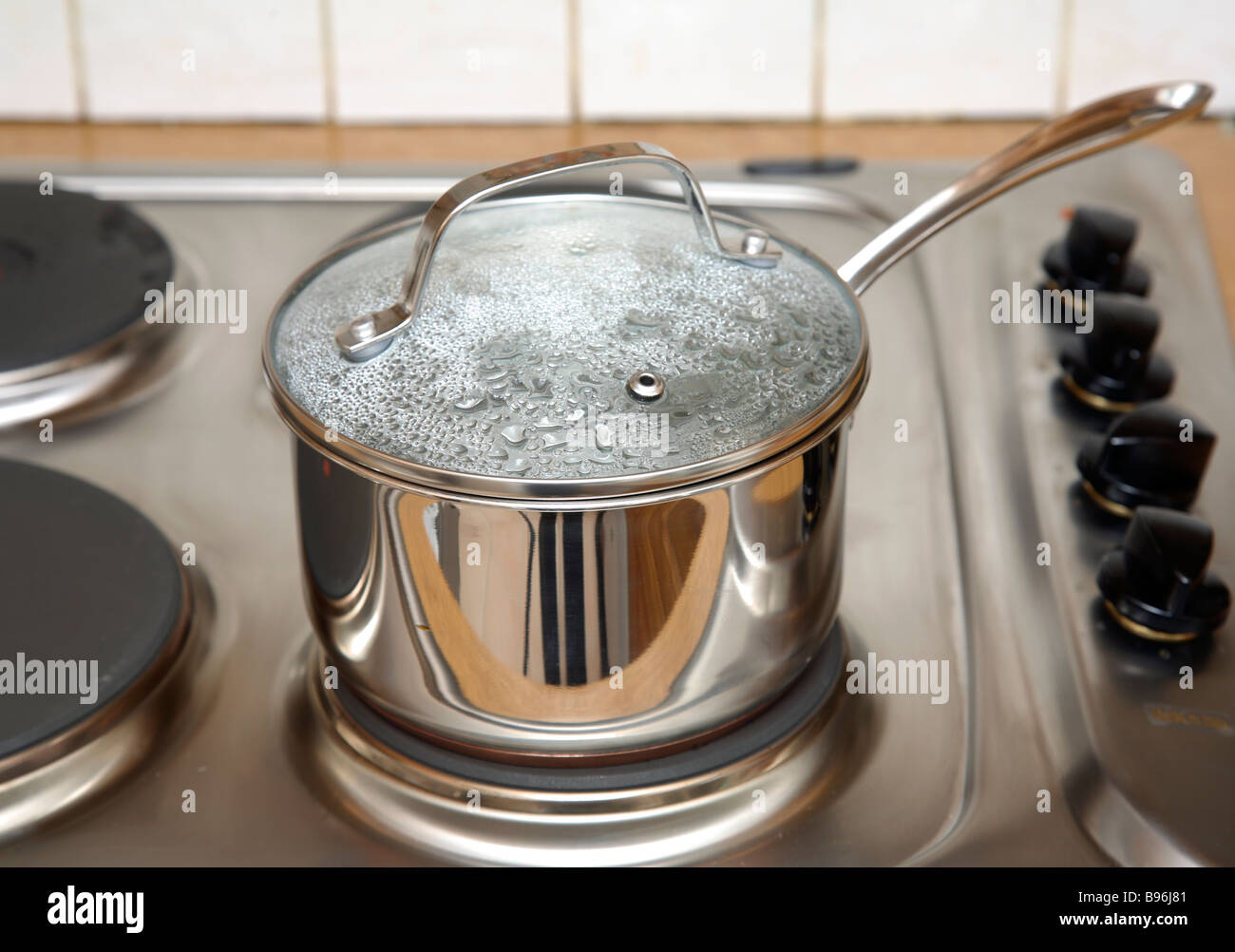 A stainless steel sausepan on a hob. Stock Photo