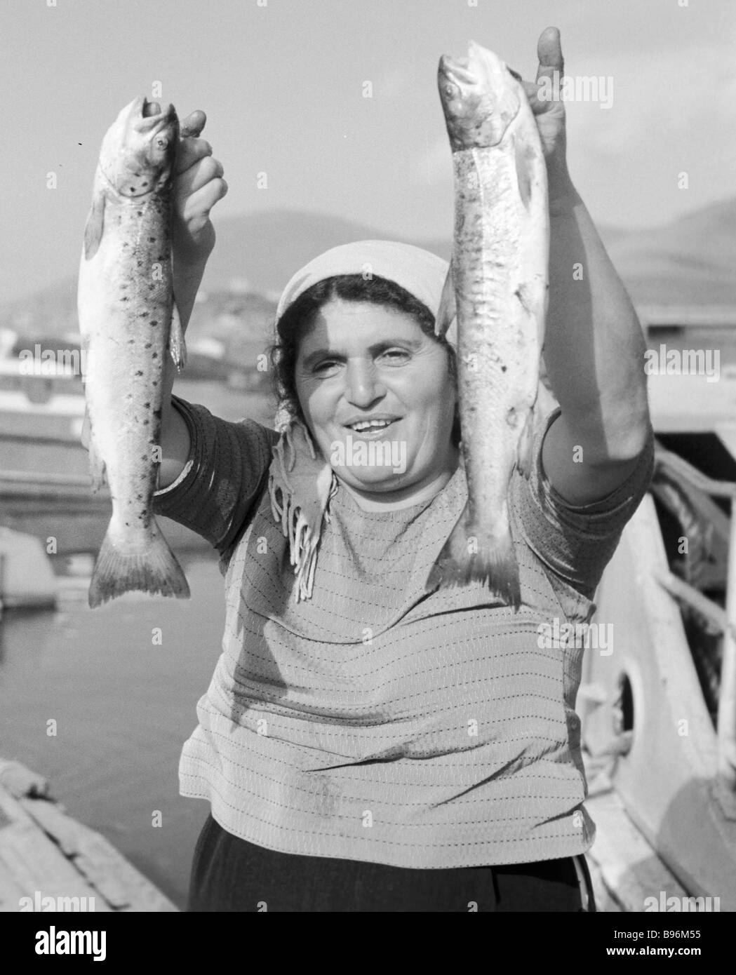 A woman showing a trout she has caught Stock Photo Alamy