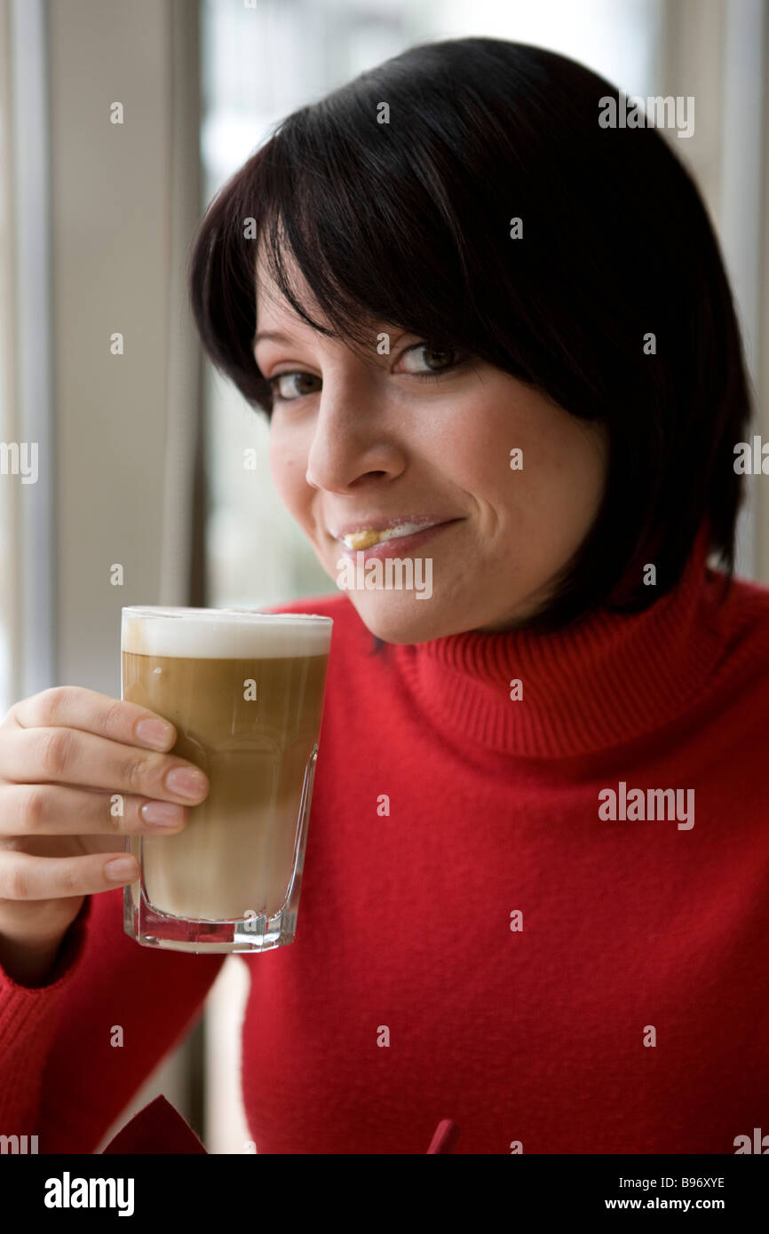 Frau hat Milch schnute beim trinken eines Latte Macchiato Stock Photo