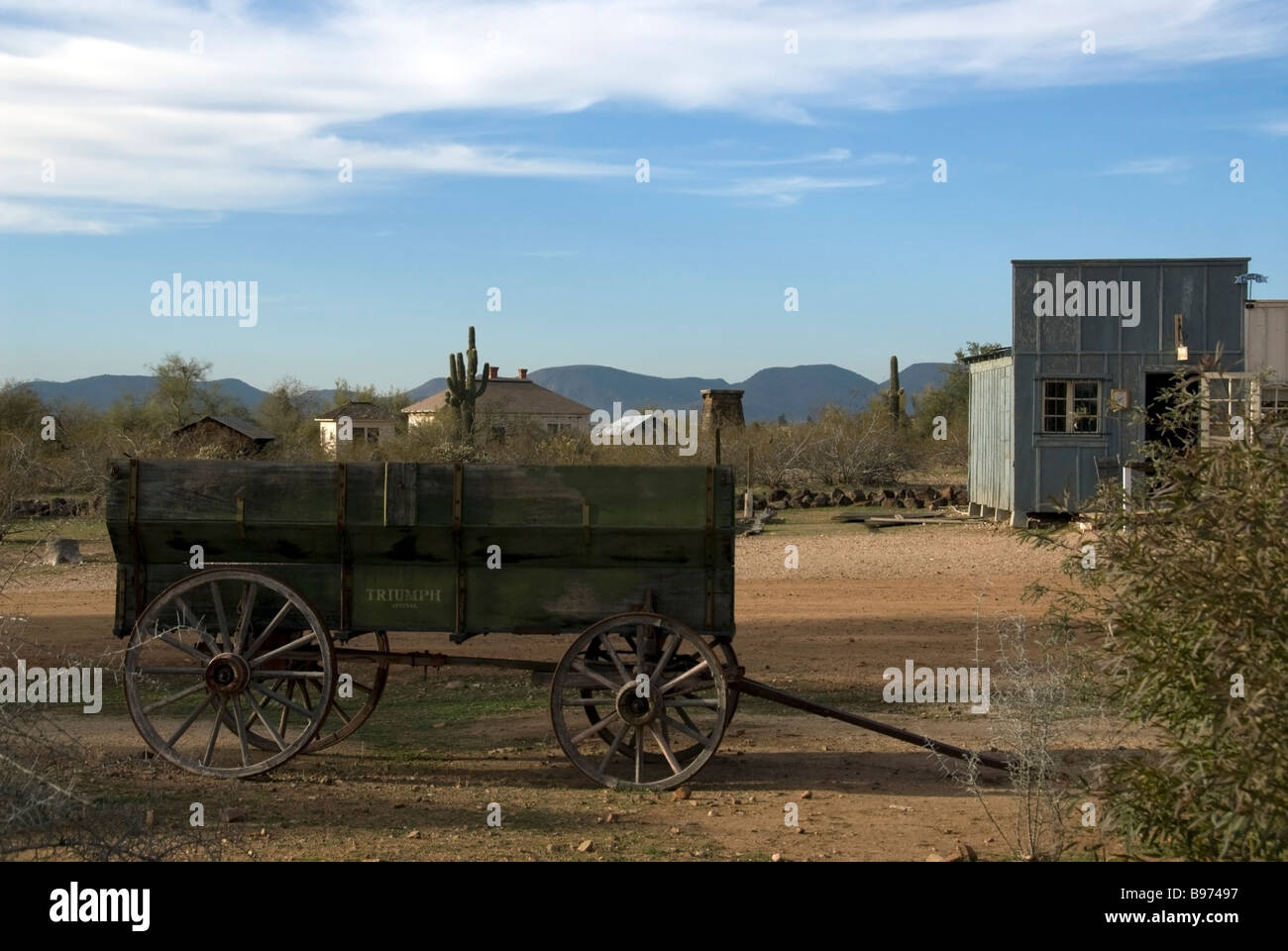 Pioneer Living History Village, Phoenix, Arizona, USA - old pioneer wagon in the foreground with old western town buildings behind it. Stock Photo