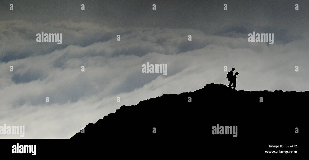 Silhouetted walkers, Helvellyn Summit, Lake District Stock Photo