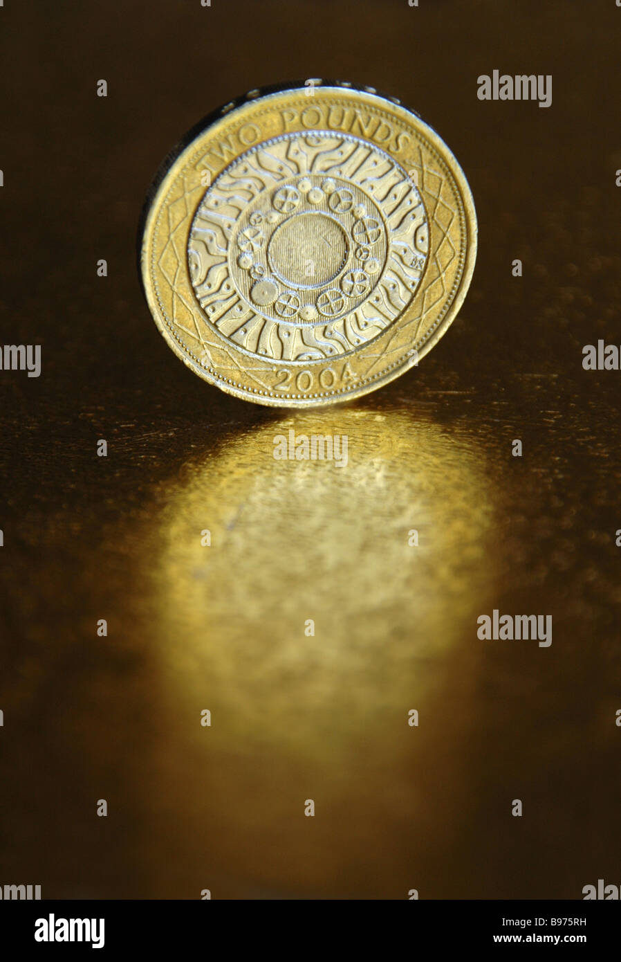 A standing 2 pound coin and its reflection. Stock Photo