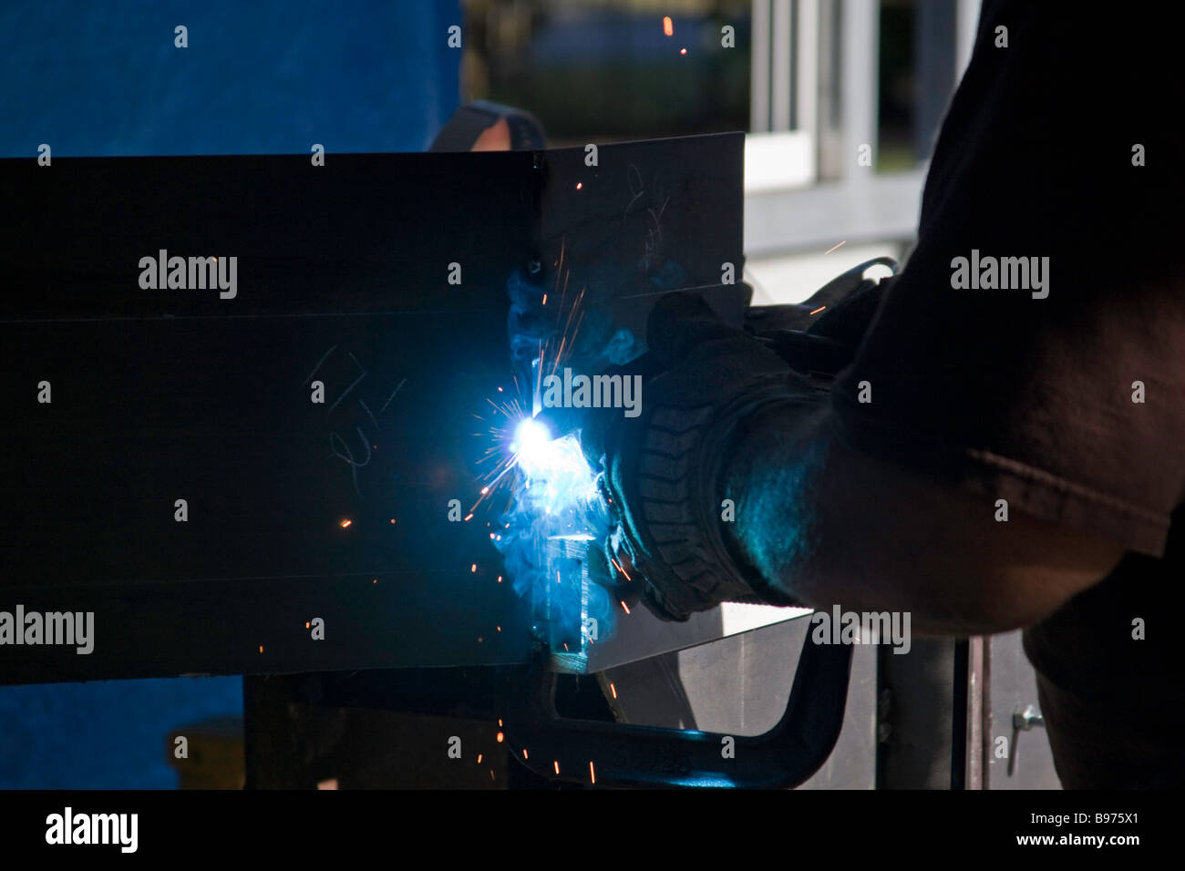 MIG Welding creates a blue arc of light while fabricating a steel bumper for a Hummer suv. Stock Photo