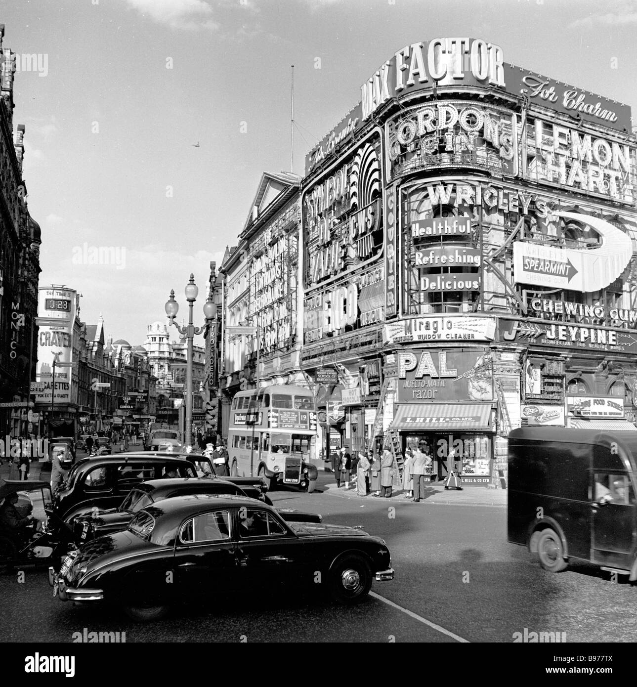 1950s, the famous tourist attraction of London, the advertising billboards and signs of Piccadilly Circus with cars of the era a busy road junction. Stock Photo