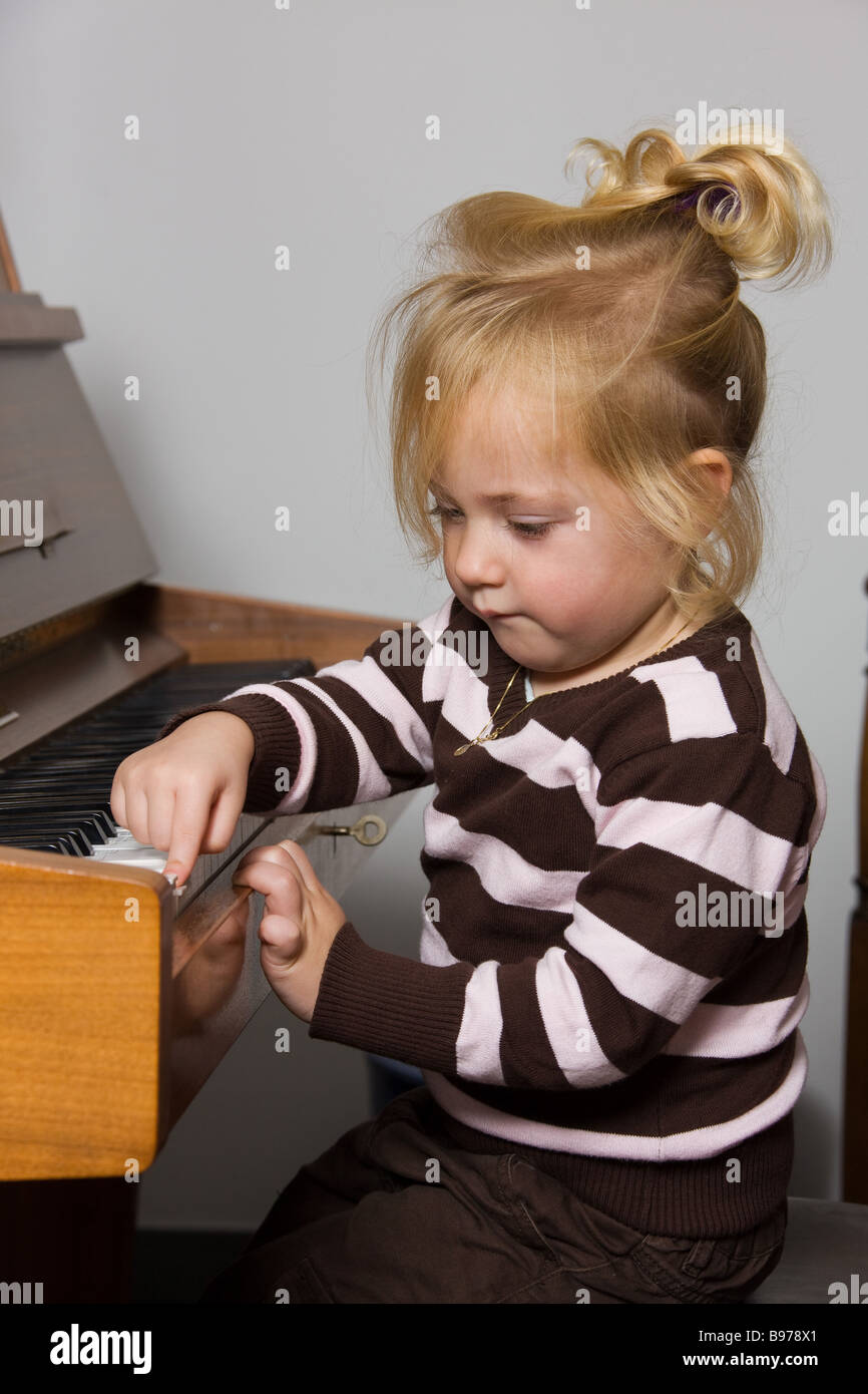 child plays on a piano Stock Photo