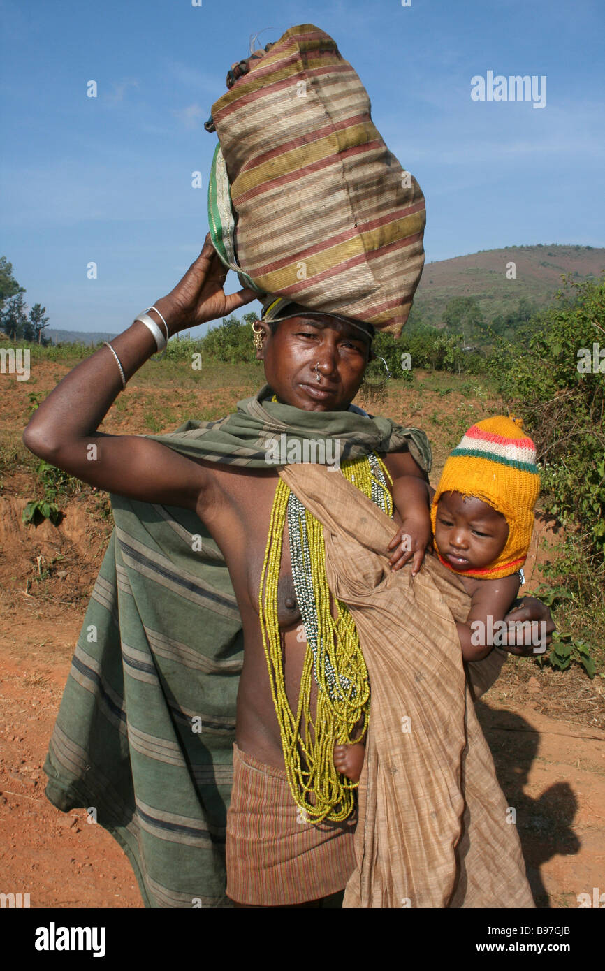 Indian Bonda Tribe Woman With Child at Hip and Carrying Bag on Head Stock Photo