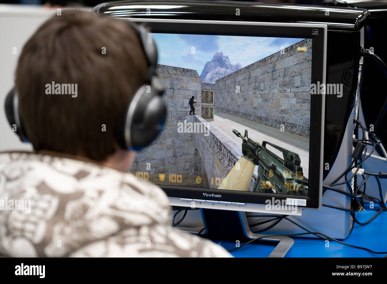 Teenager playing a violent game egoshooter at the computer Stock Photo