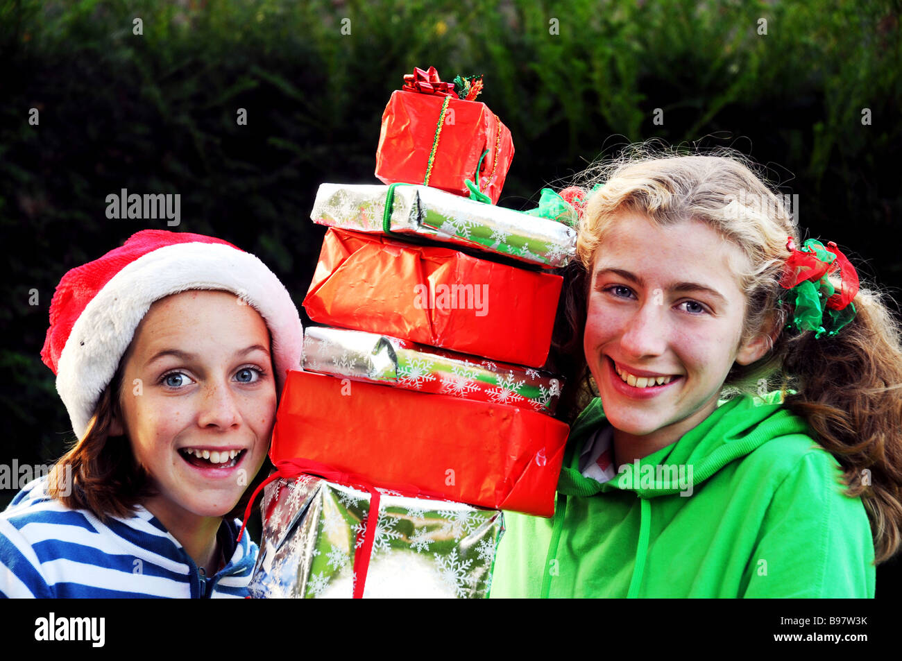 portrait of two girls carrying xmas presents Stock Photo