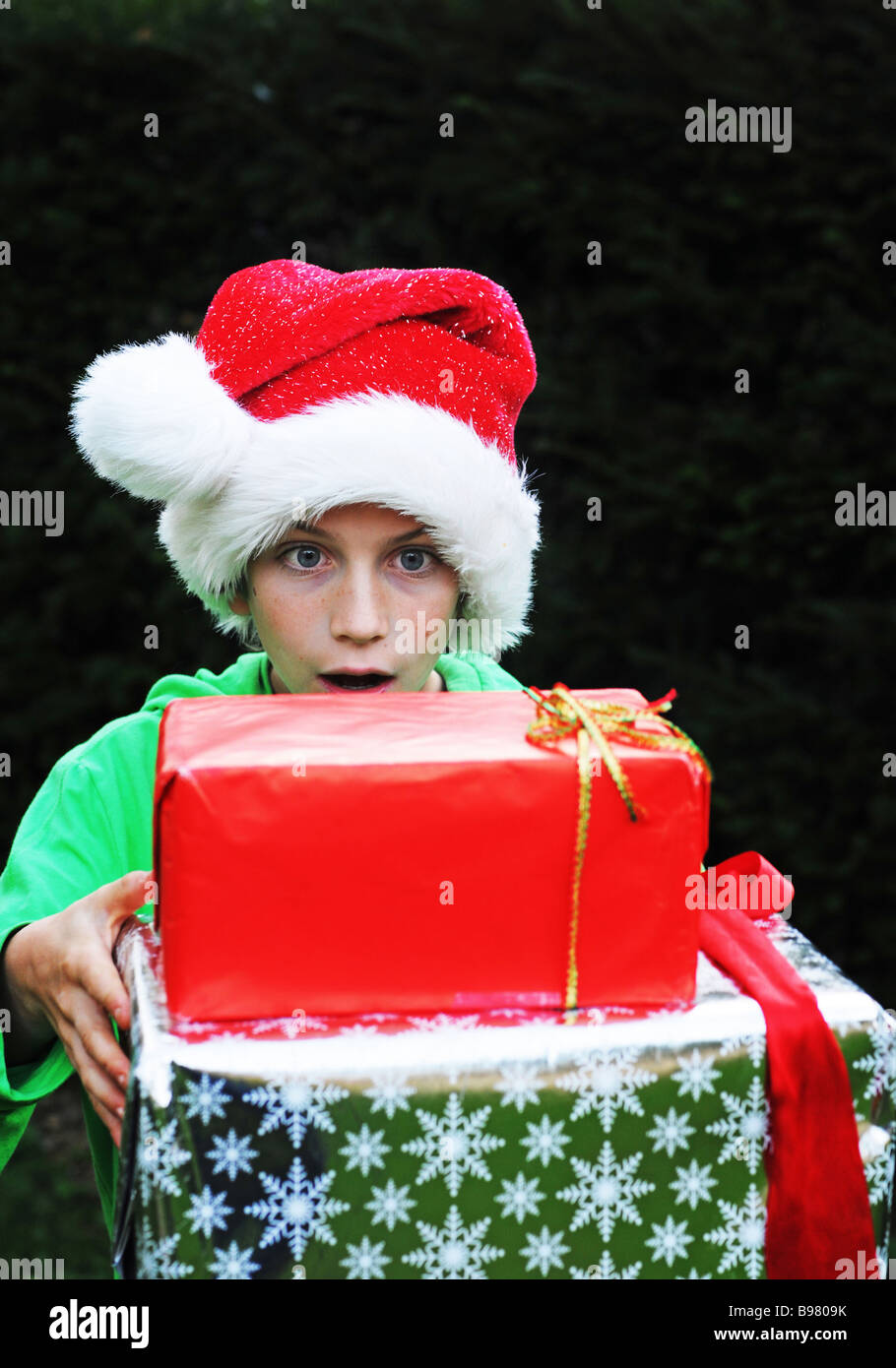 boy in santa hat receiving presents Stock Photo