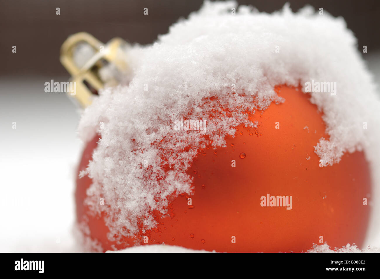 Red bauble covered with snow outside Stock Photo
