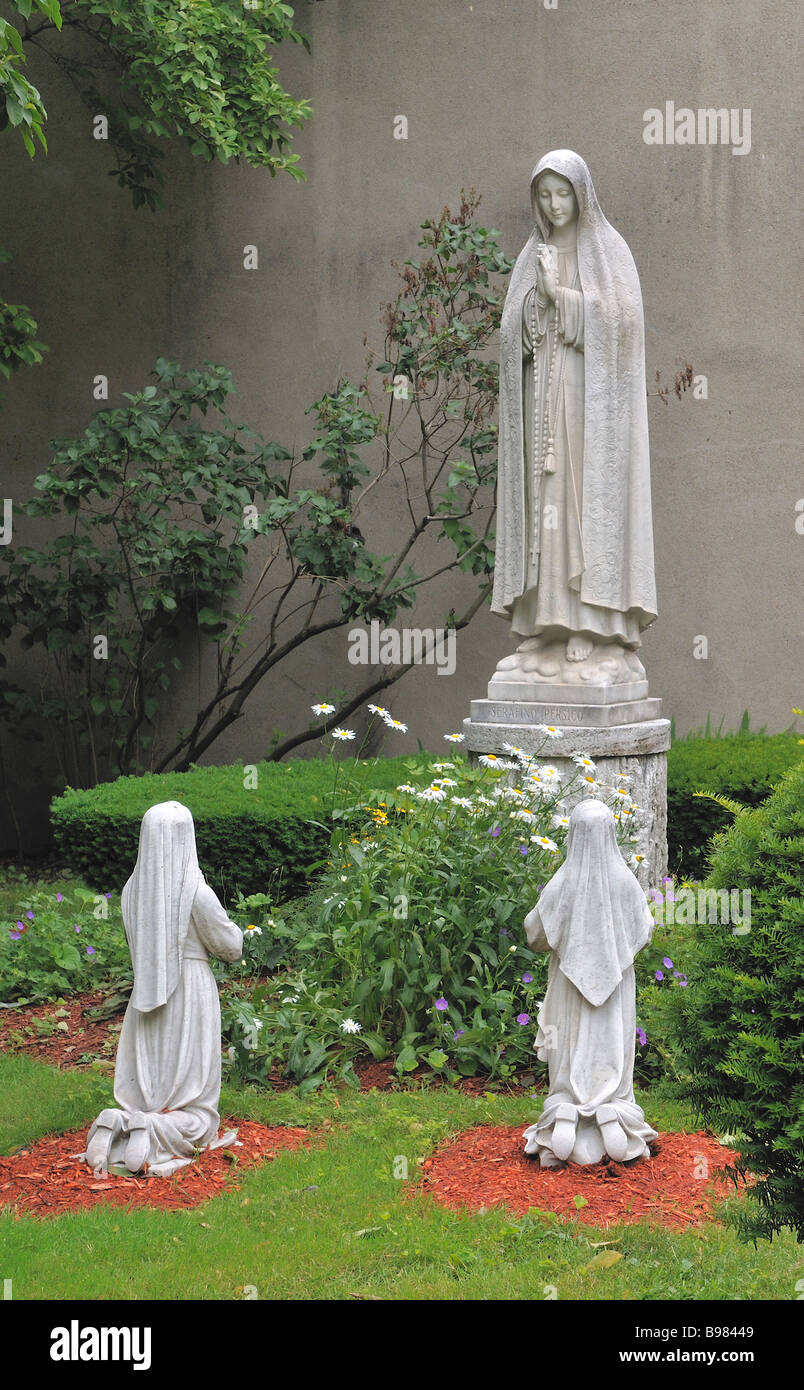 tree statues of praying woman in the garden Stock Photo