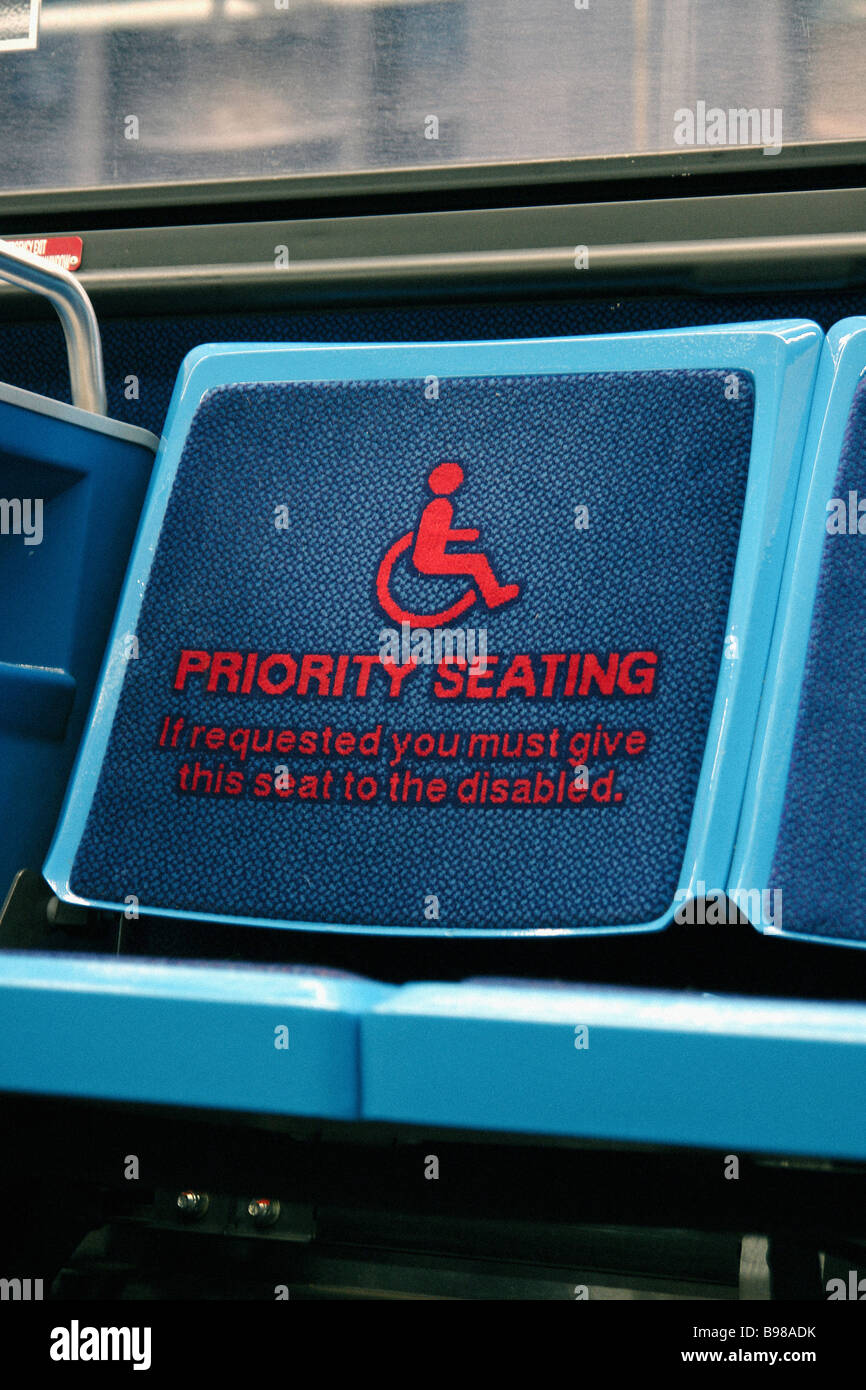 Empty seat on a public transportation bus jitney displaying a wheelchair and stating that it is handicapped priority Copy Space Stock Photo