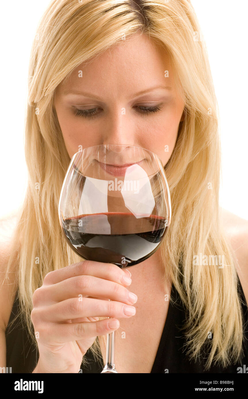 Close-up of an attractive blonde woman sipping on a glass of red wine Stock Photo