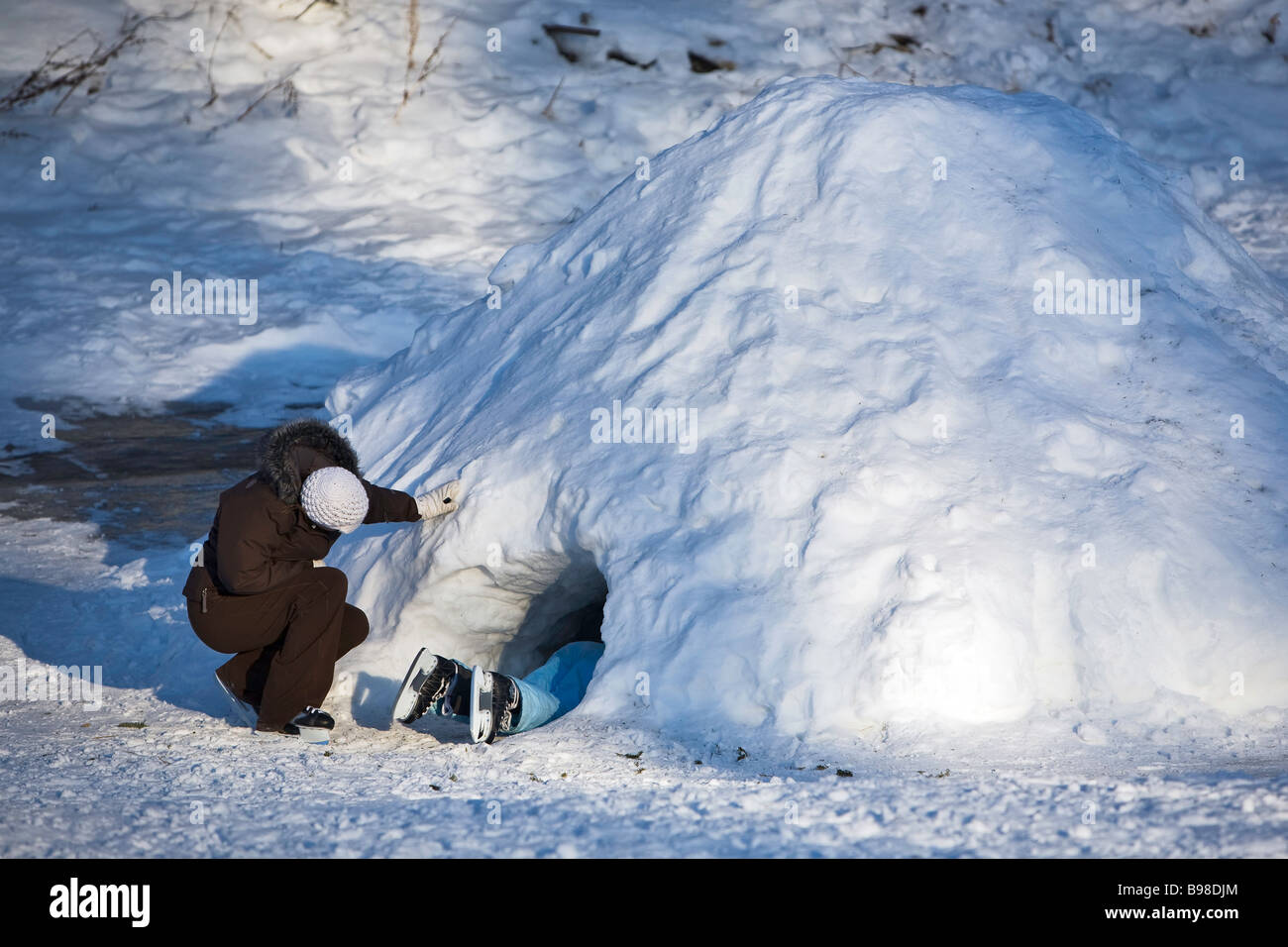 Young child exploring a quinzee or snow cave. Stock Photo