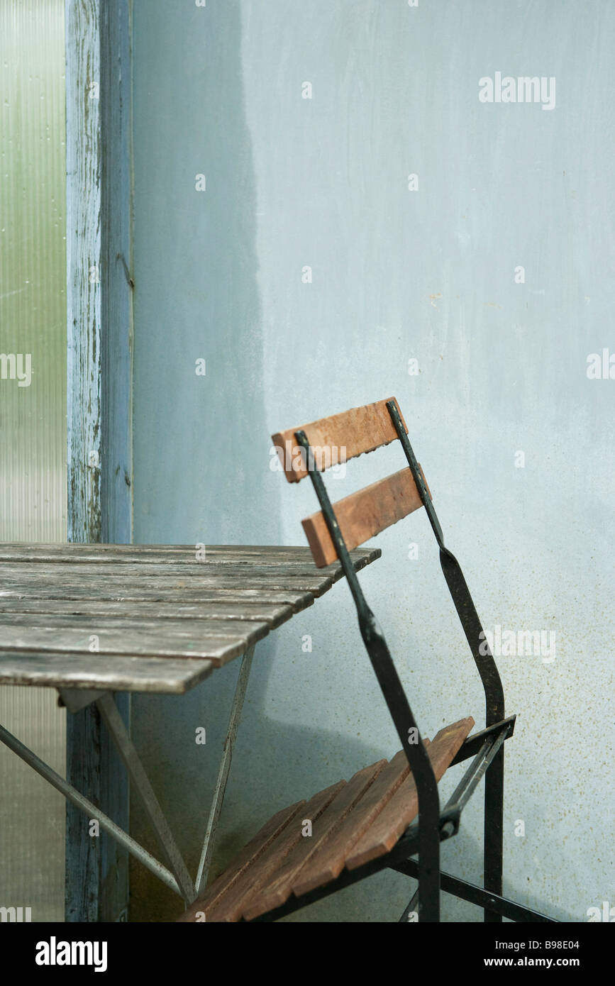 Folding chair leaning against table Stock Photo