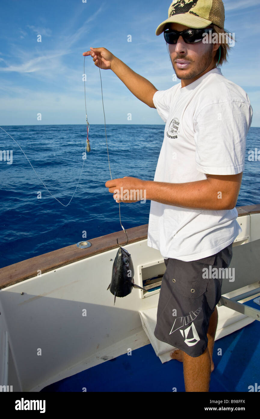 Big game fishing fisherman preparing bonito lure on fishingboat Saint Gilles La Réunion France Stock Photo