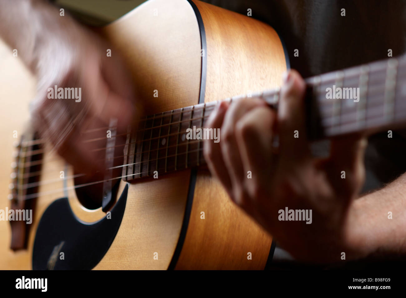 Guy playing acoustic guitar Stock Photo