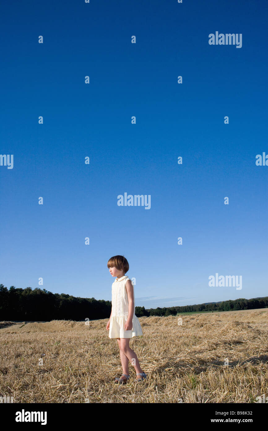 Young girl standing alone in field Stock Photo - Alamy, image size:866x1390