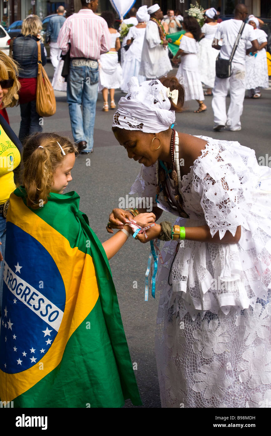 A traditional bahian maedesanto offers a ribbon from the Senhor do Bonfim church to a child in