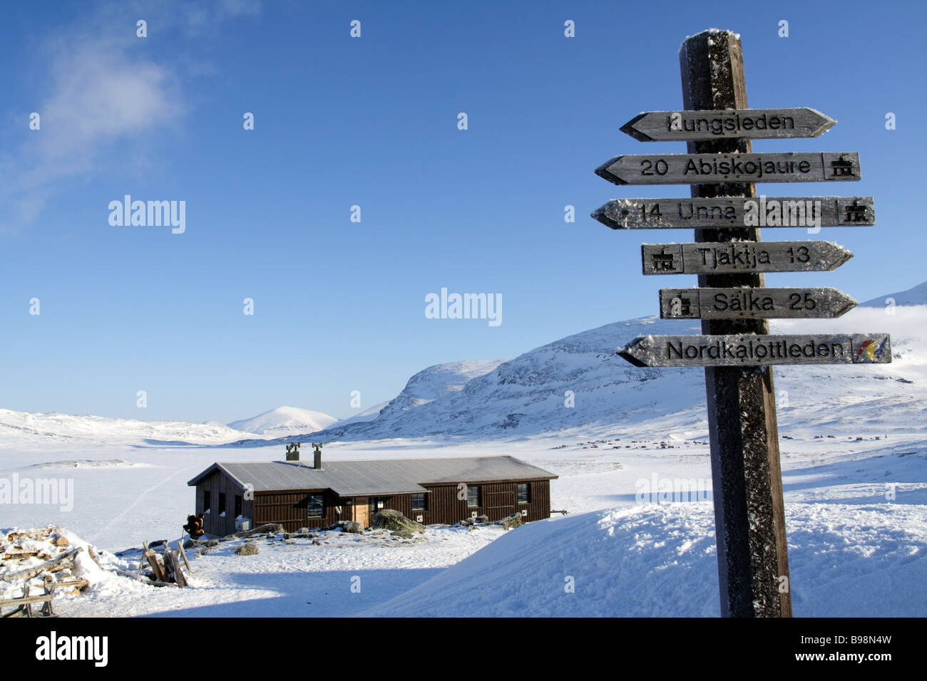 Hut by frozen lake and signs along the Kungsleden, Sweden Stock Photo
