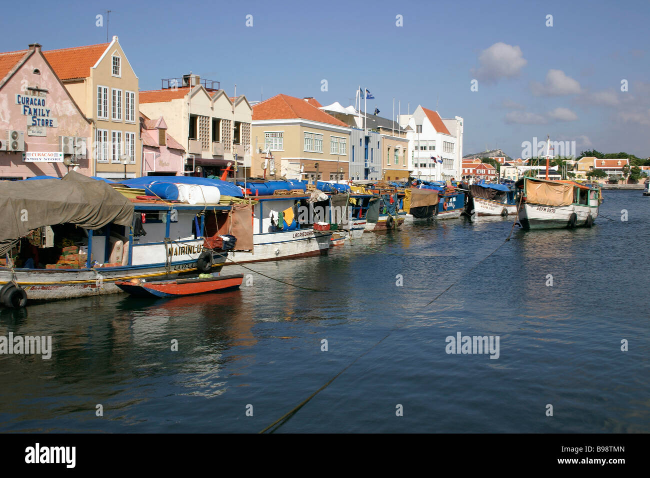 Dutch Antilles Capital Harbour wall Quayside Historic houses Floating market Stall Boats laden with goods  WILLEMSTAD CURACAO Stock Photo