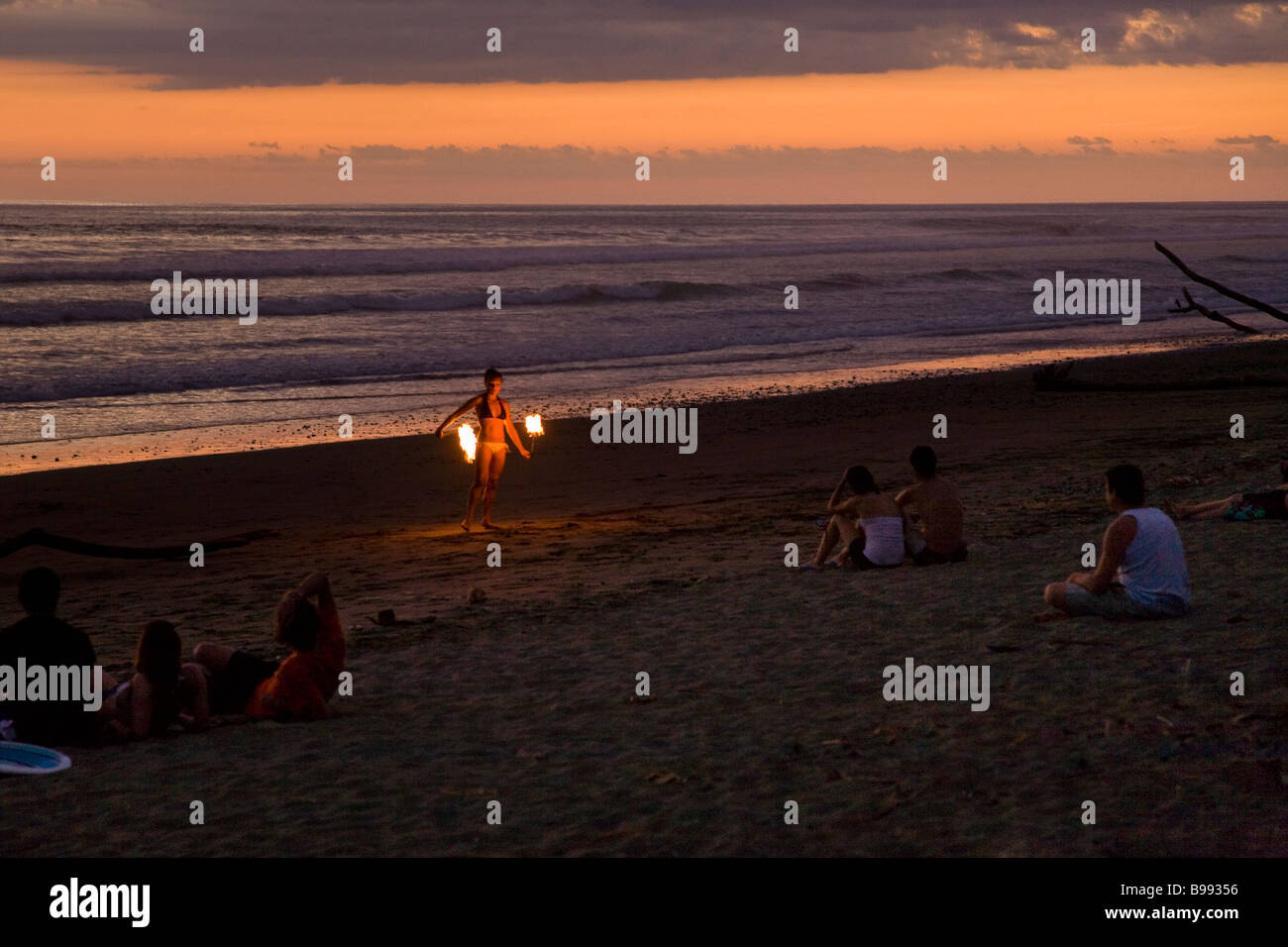 A fire dancer juggling torches at sunset in Dominical, Costa Rica. Stock Photo