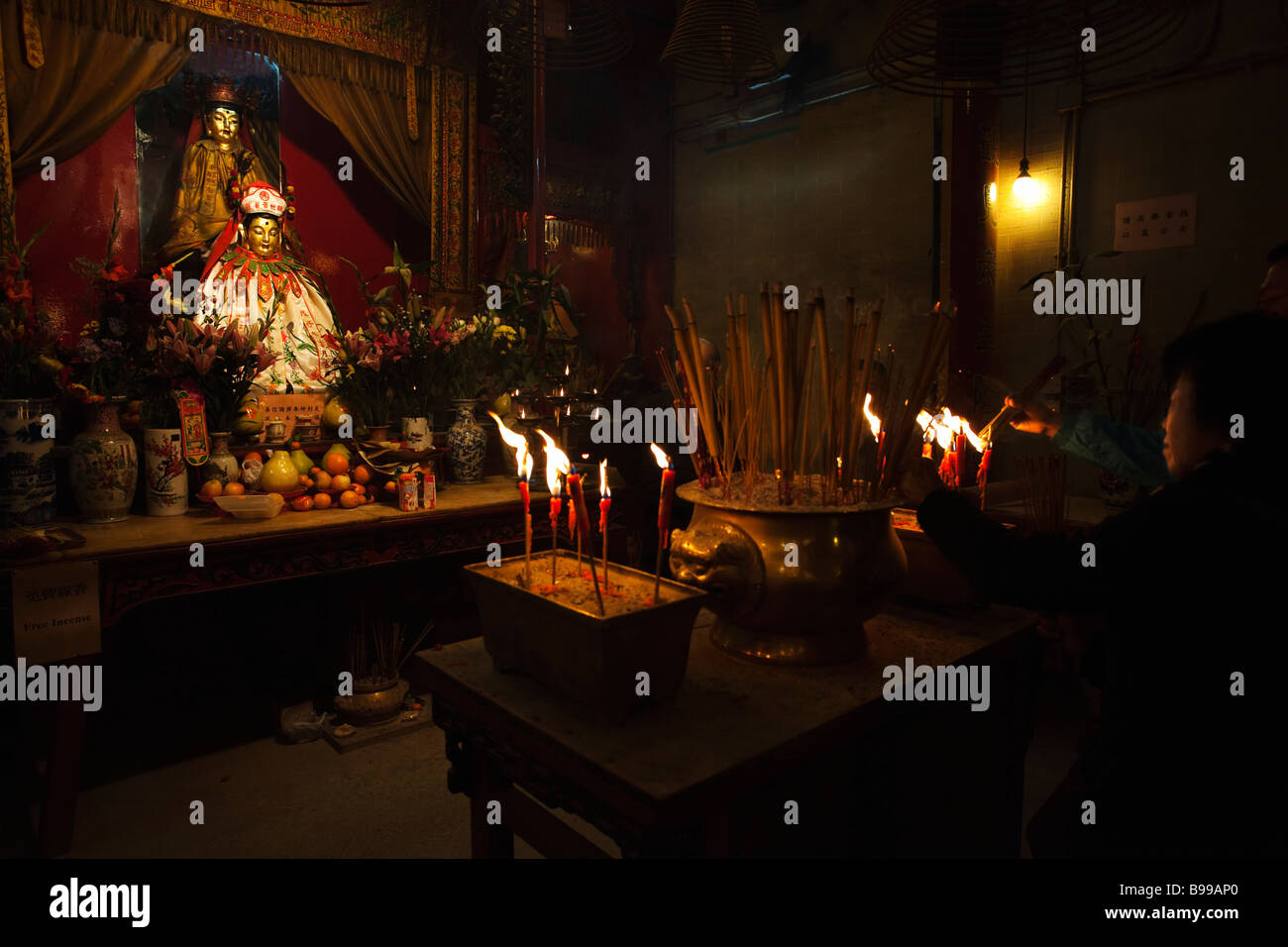 Devotee lighting candle Man Mo temple Hong Kong Stock Photo Alamy