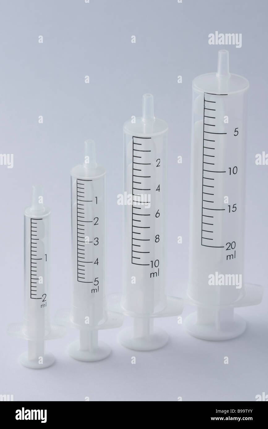 Four empty syringe barrels of increasing sizes 2ml 5ml 10ml and 20ml Stock Photo