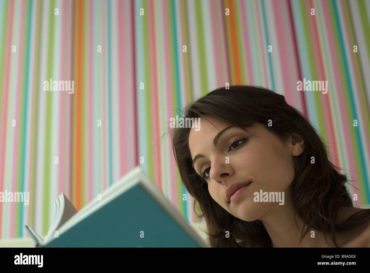 Young woman reading book, low angle view Stock Photo