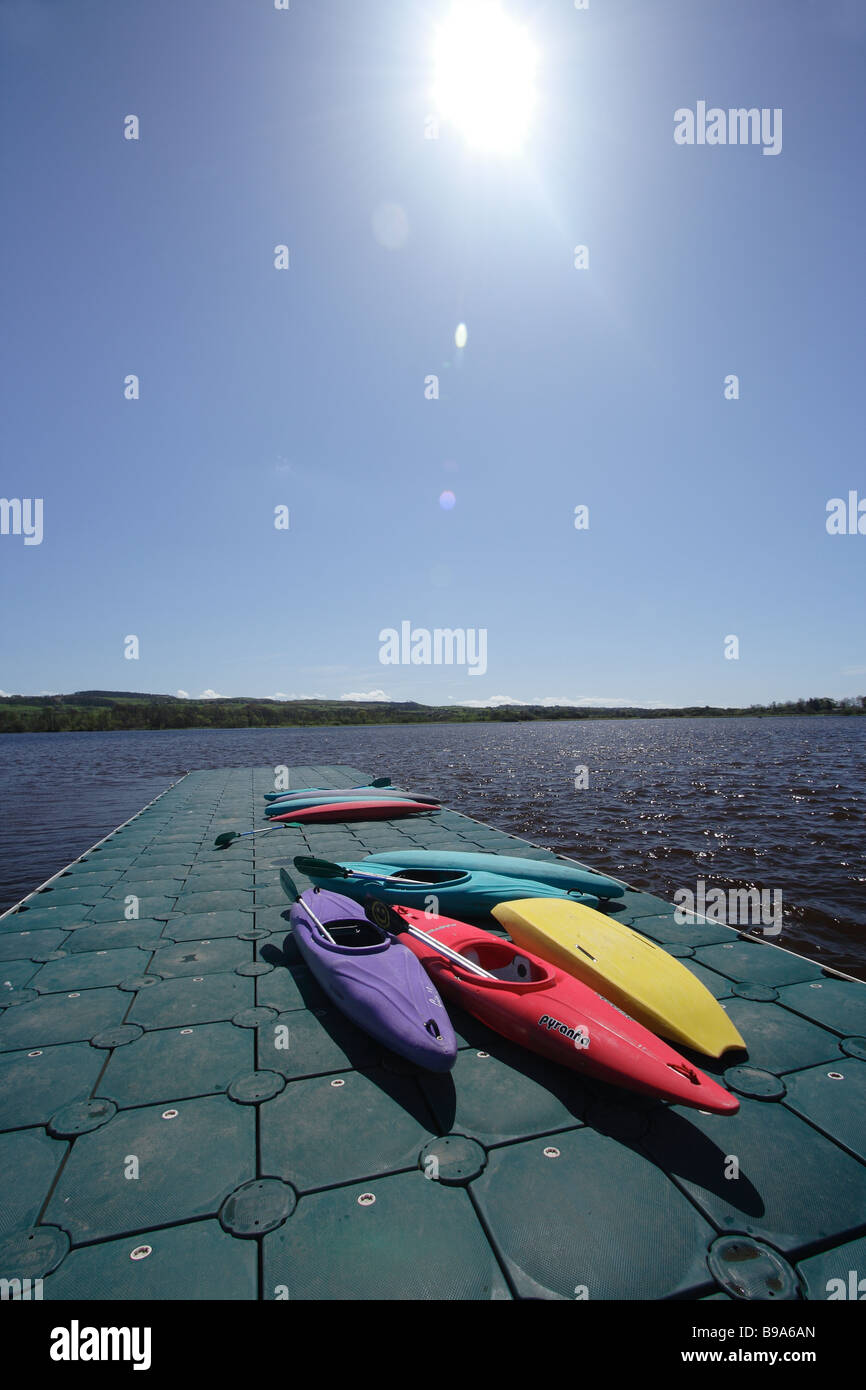 Canoes on a jetty in summer sun at Castle Semple Loch, Clyde Muirshiel Regional Park, Lochwinnoch, Renfrewshire, Scotland UK Stock Photo