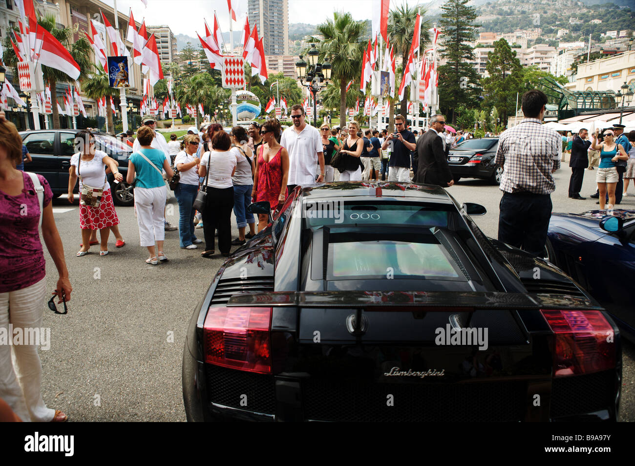 The rear of a black Lamborghini parked outside the Casino de Paris in Monaco Monte Carlo with tourists walking around. Stock Photo