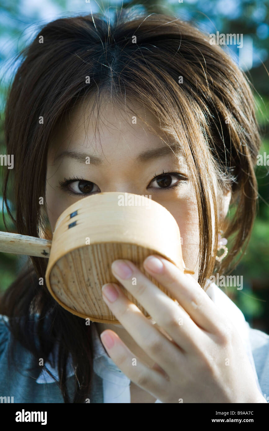 Female drinking from traditional Japanese hishaku ladle, close-up Stock Photo