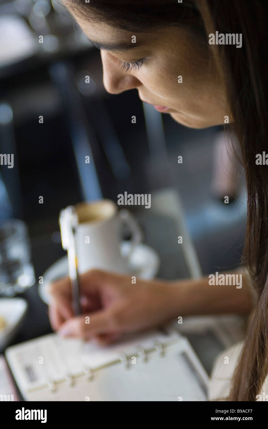 Woman writing in agenda, cropped Stock Photo