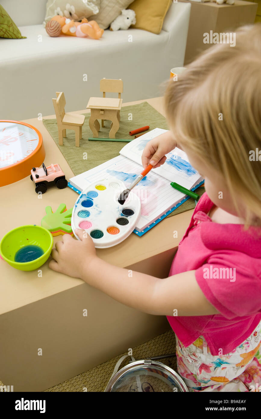 Little girl painting with watercolors Stock Photo - Alamy