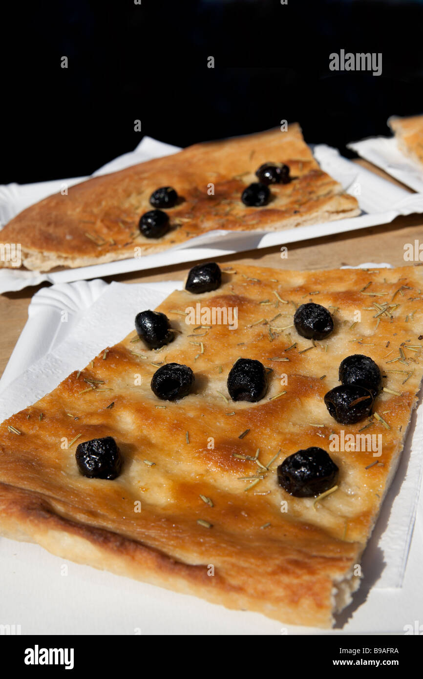 A fresh flat bread topped with black olives at the outdoor market Switzerland Stock Photo
