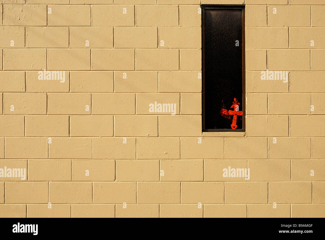 Brick wall with a red cross in a window Stock Photo - Alamy