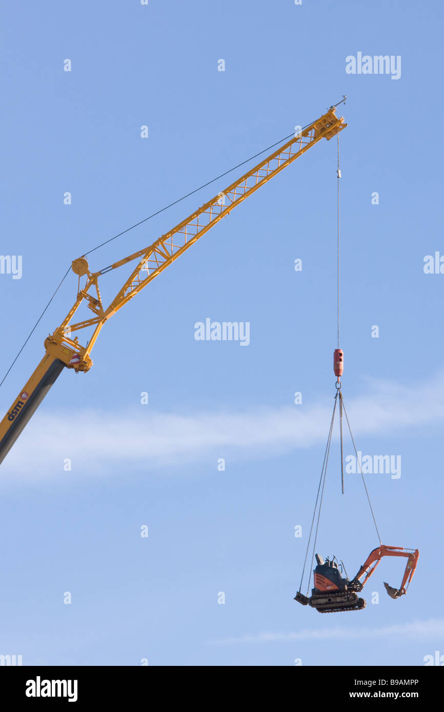 A large crane lifts an excavator into the sky Stock Photo Alamy