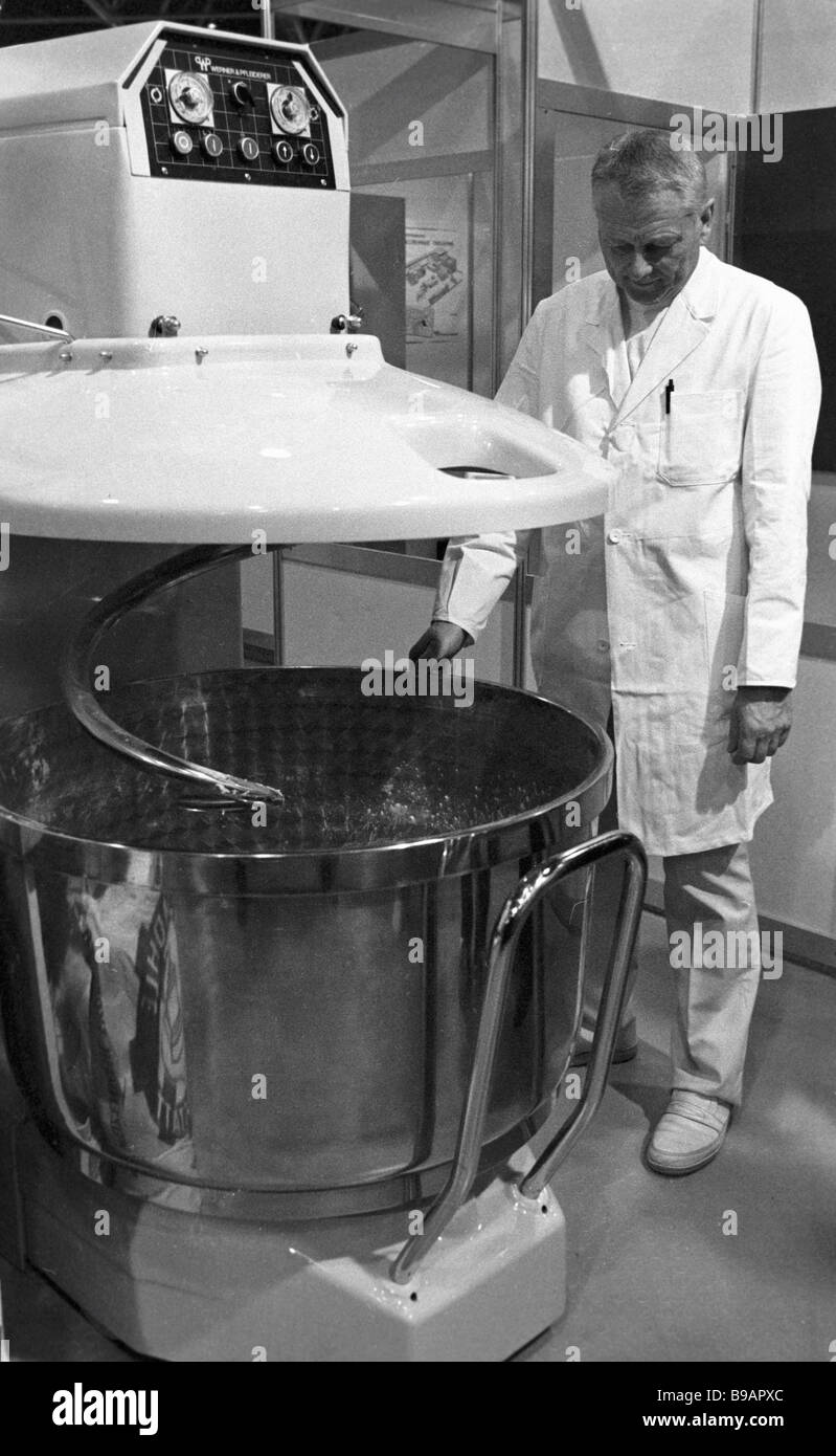 Baker watching the operation of the German dough mixer manufactured by the Werner Pfleiderer company Stock Photo