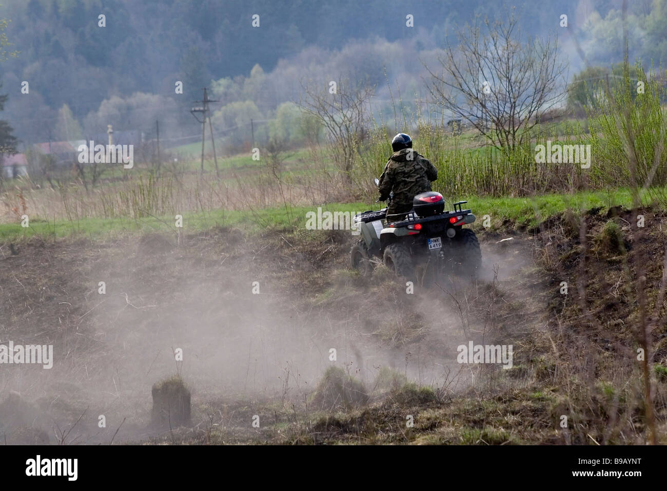 Poland, Bieszczady, Man riding quadbike through marshland Stock Photo