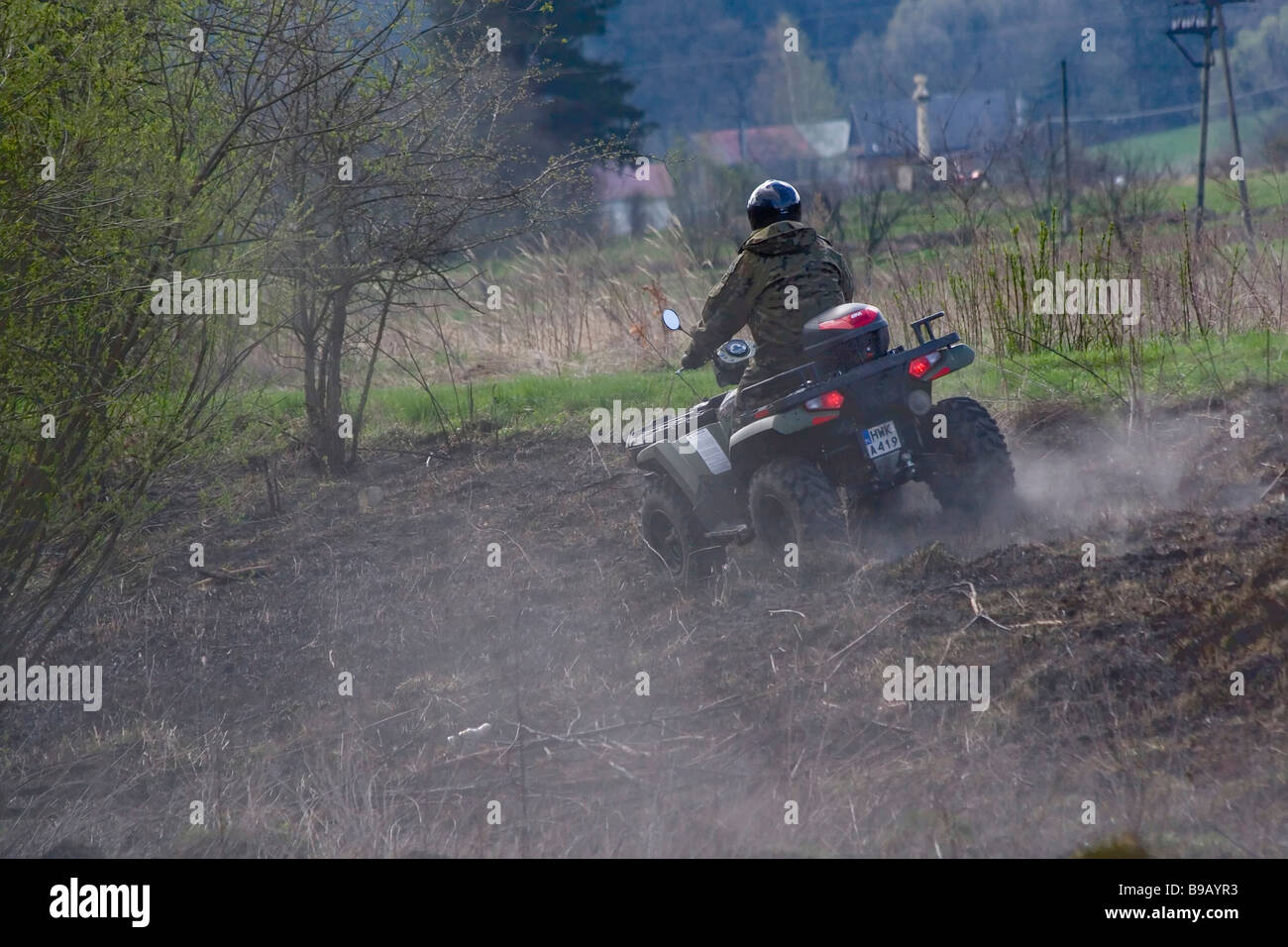 Poland, Bieszczady, Man riding quadbike through marshland Stock Photo