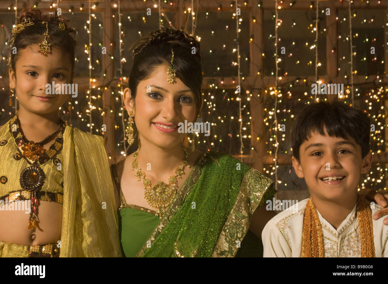 Family smiling in front of Diwali decoration Stock Photo