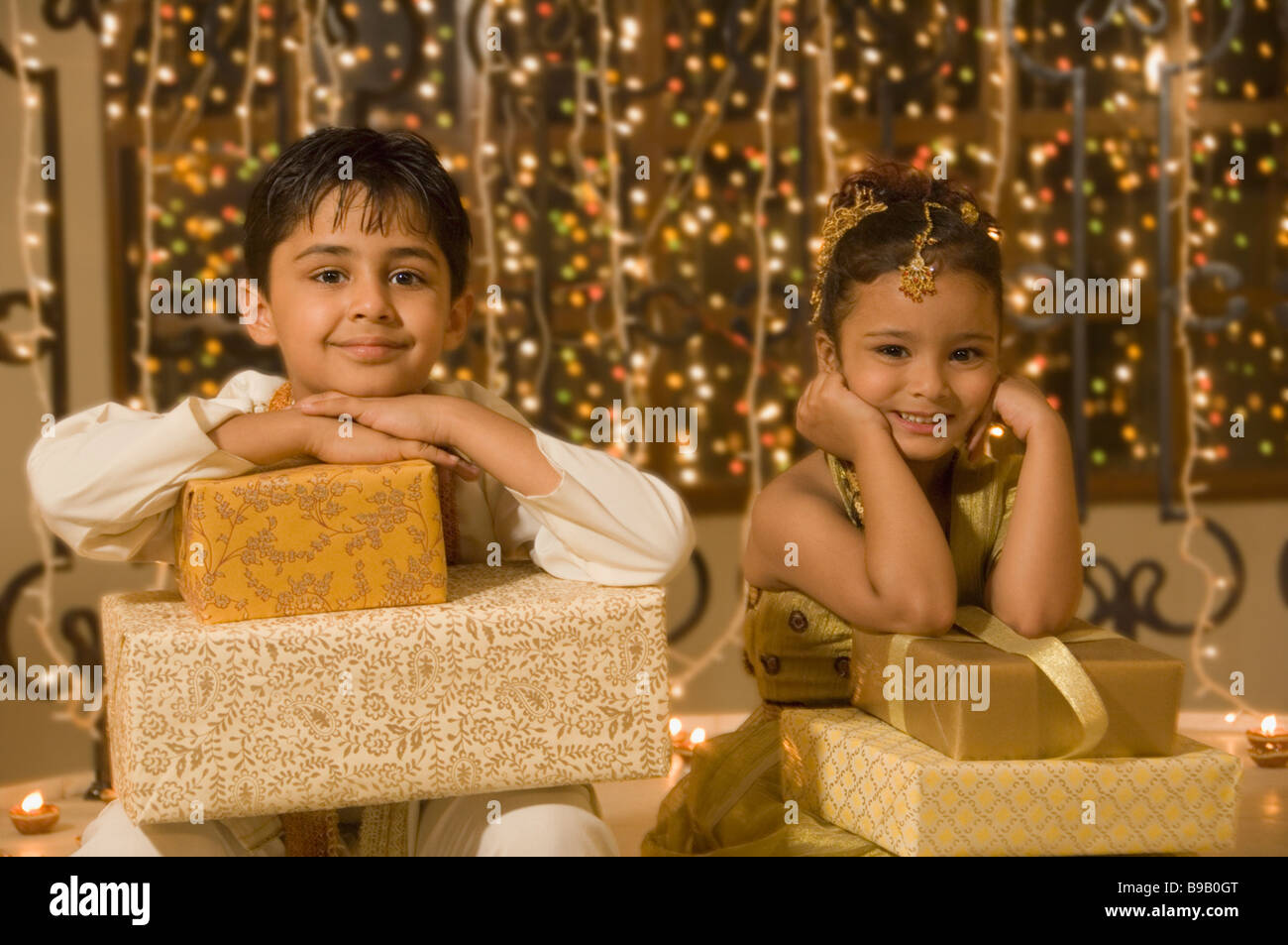 Boy sitting with his sister and holding Diwali gifts Stock Photo