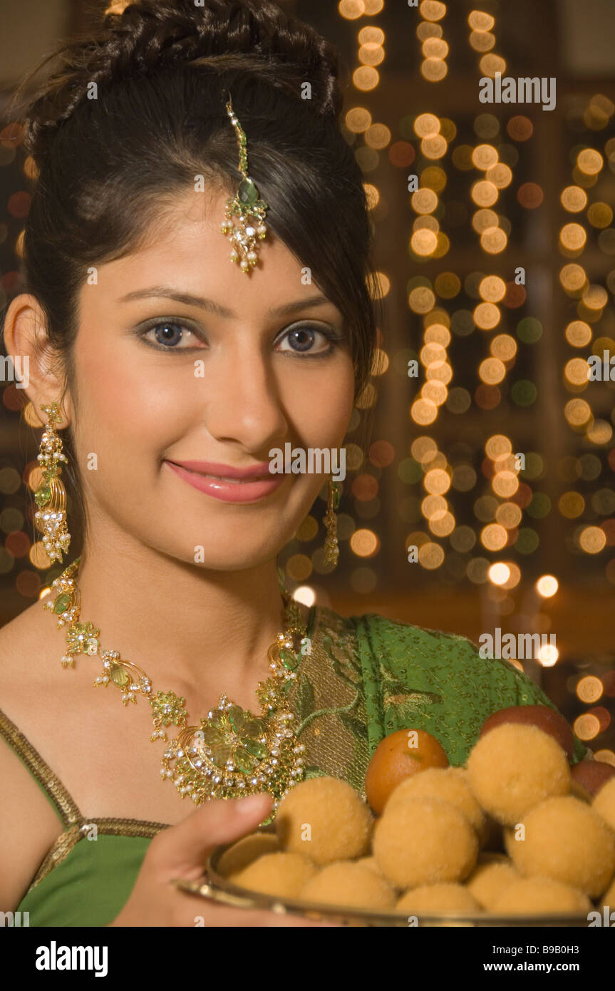 Woman holding a plate full of sweets Stock Photo - Alamy