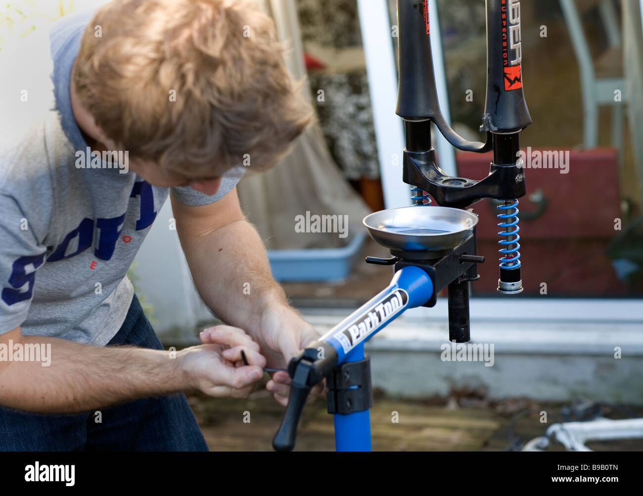 A man rebuilds a pair of mountain bike forks on a workstand Stock Photo