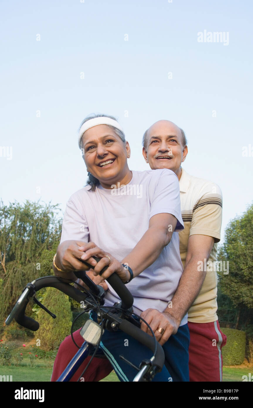 Couple cycling in a park, New Delhi, India Stock Photo