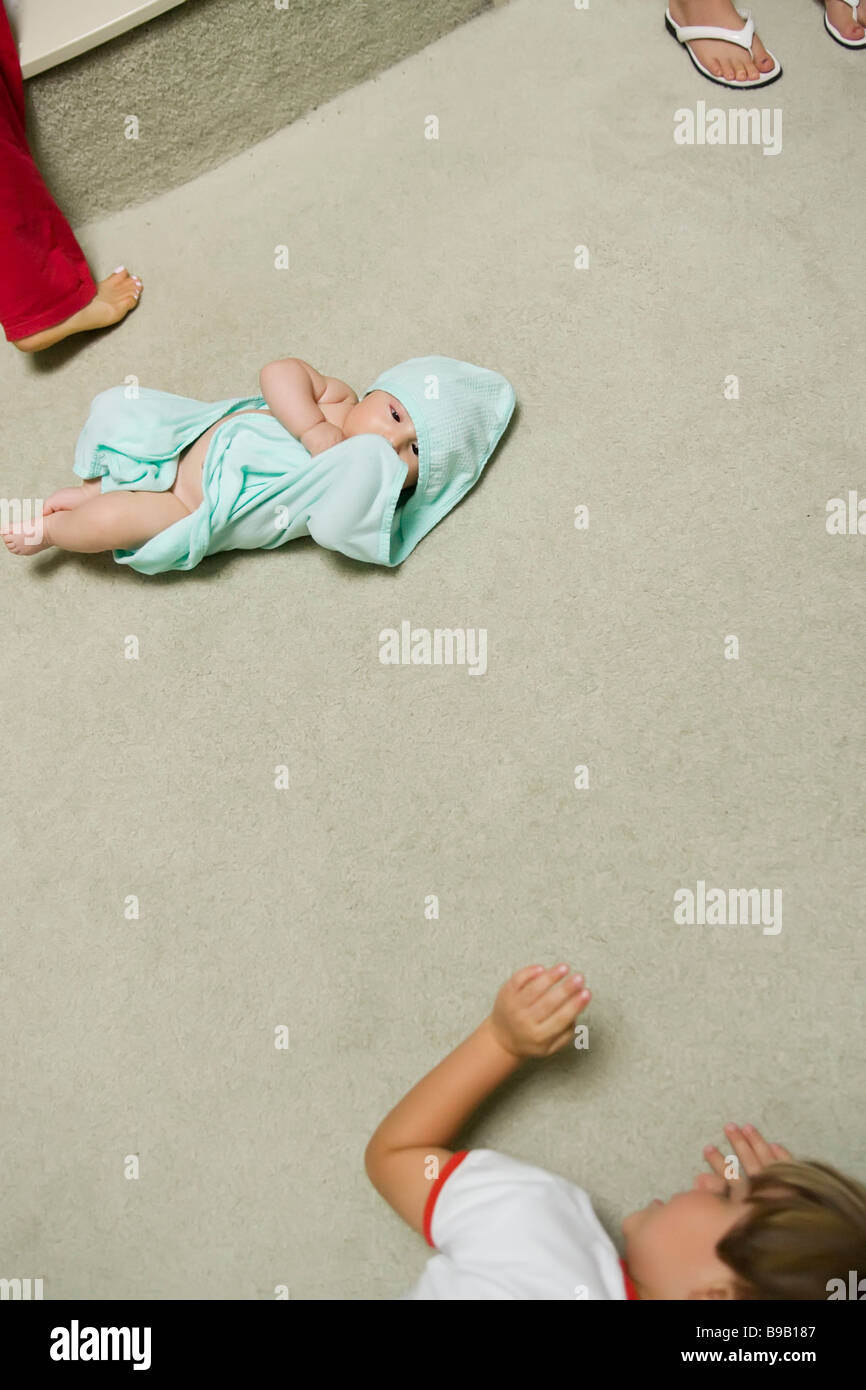 a boy watches his infant brother snuggled in a towel Stock Photo Alamy