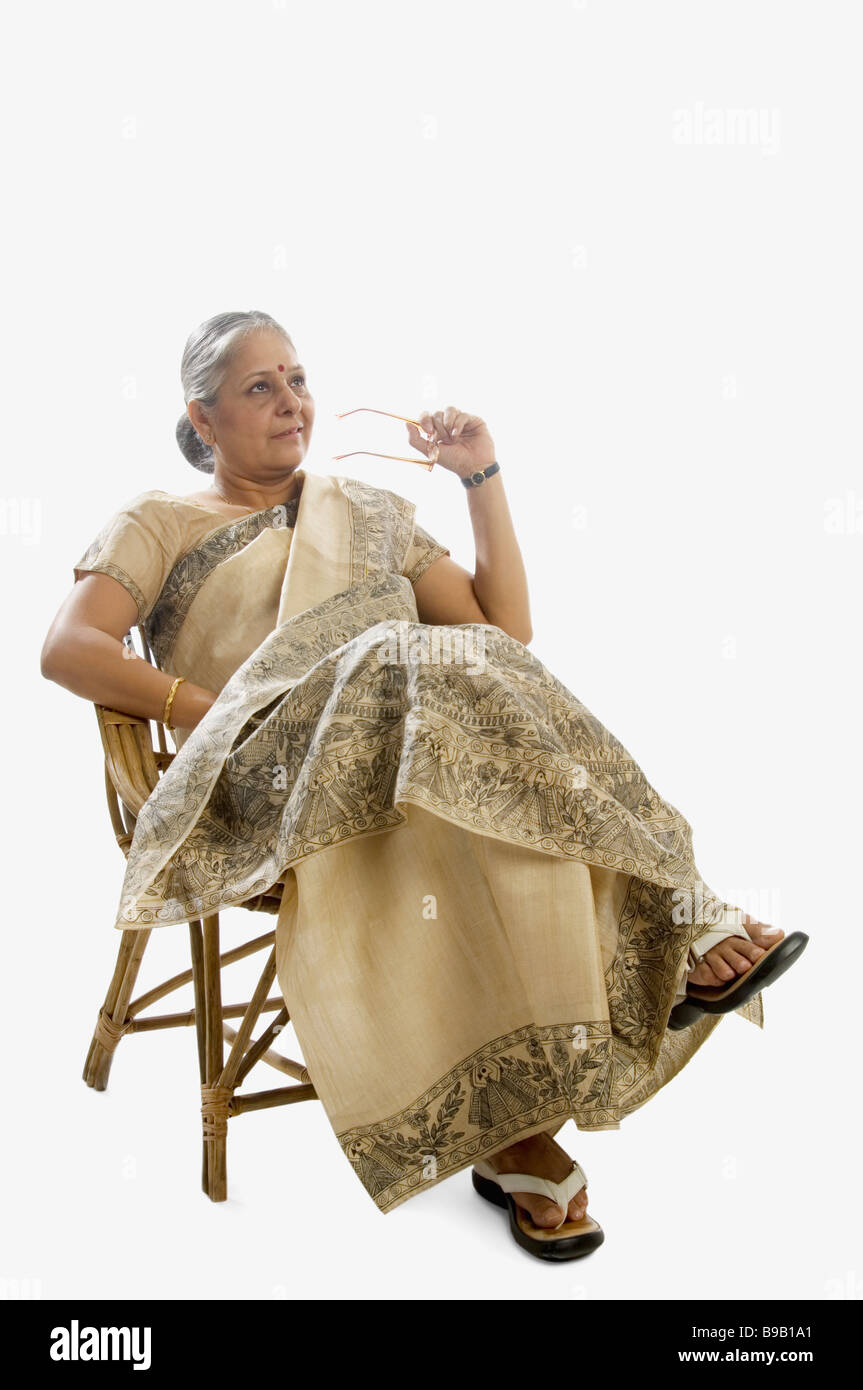 Woman sitting on a chair and day dreaming Stock Photo Alamy