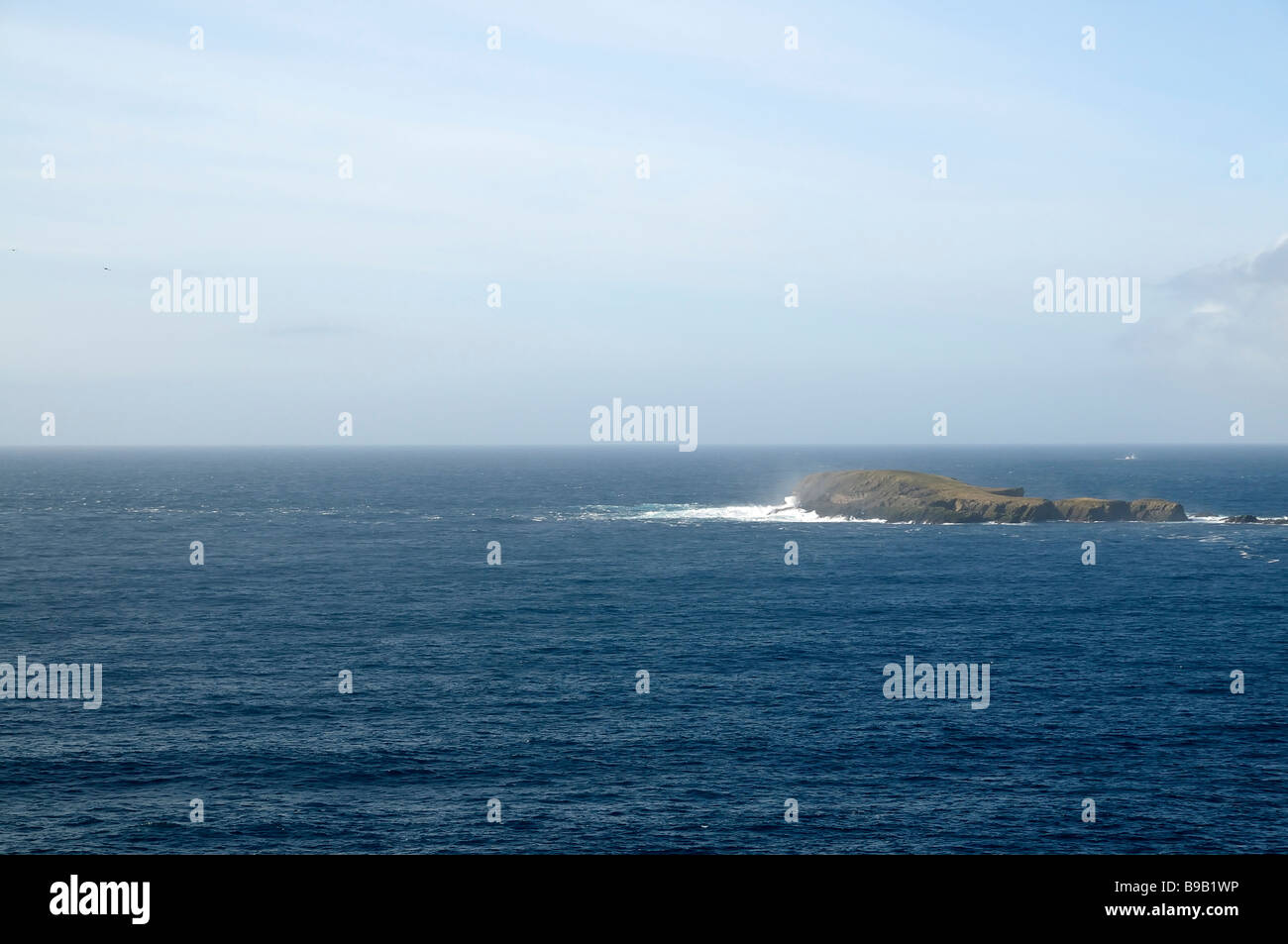 Small island off Shetland mainland, near Sumburgh, being hit by waves. Stock Photo